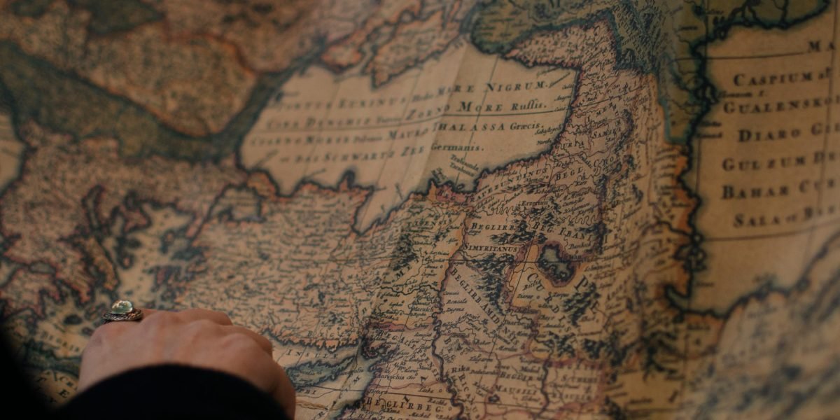 A person intently studying a complex map, illustrating the challenge of navigating the Malazan world.