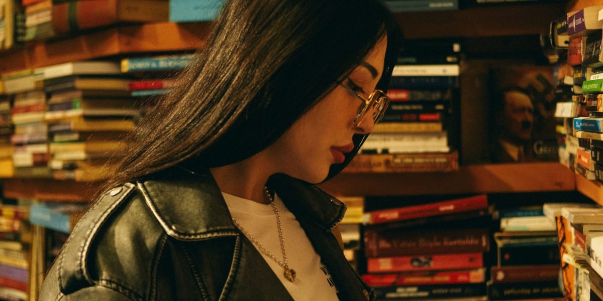 A person browsing a diverse collection of books, considering their next read.