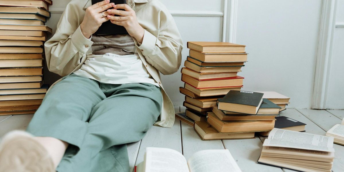 A person looking at a vast collection of books, contemplating where to begin a lengthy series.