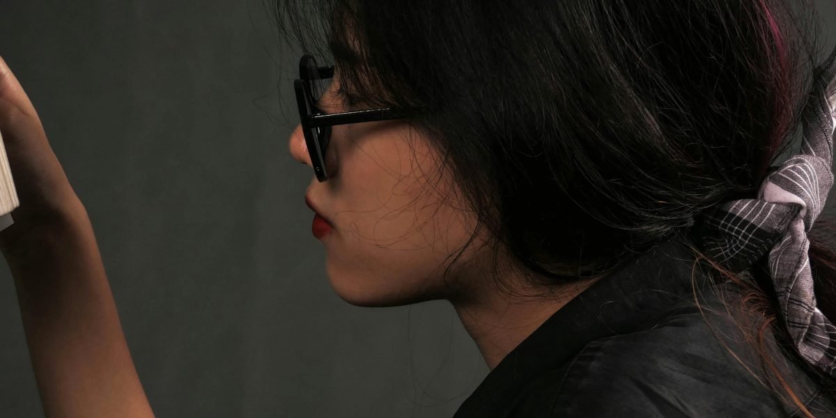 A reader contemplating their next literary journey, moving from fantasy to thought-provoking dystopian worlds.