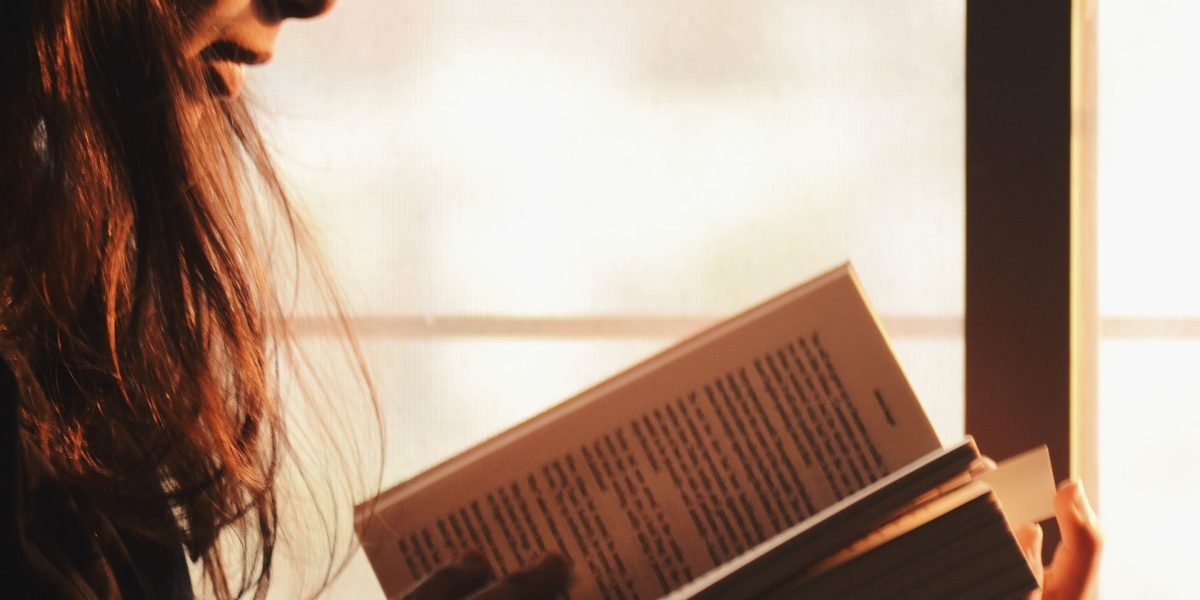 An individual thoughtfully organizing their book choices, creating a tailored reading list.